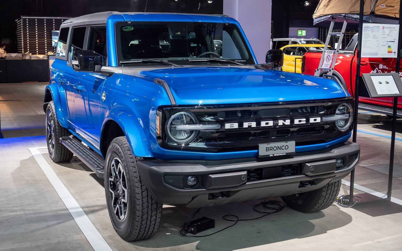 Four-door Ford Bronco in bright blue, front three-quarter view